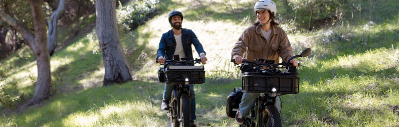 A man and woman ride Radster Trails on a rural, grassy trail.