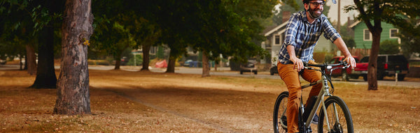 A man happily rides a RadMission on a fall day.