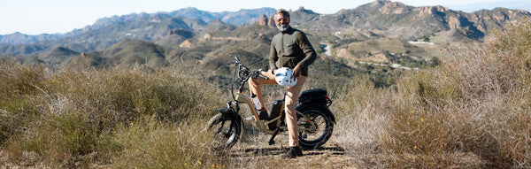 A man poses on his RadExpand 5 Plus in a desert environment.