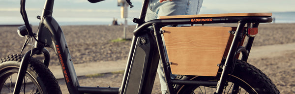 A rider stands next to his RadRunner equipped with wood panels.