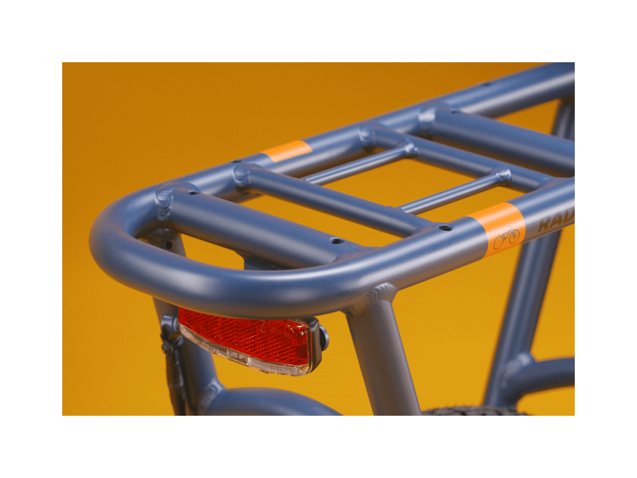 A blue electric bike rack and red taillight against a gold background.