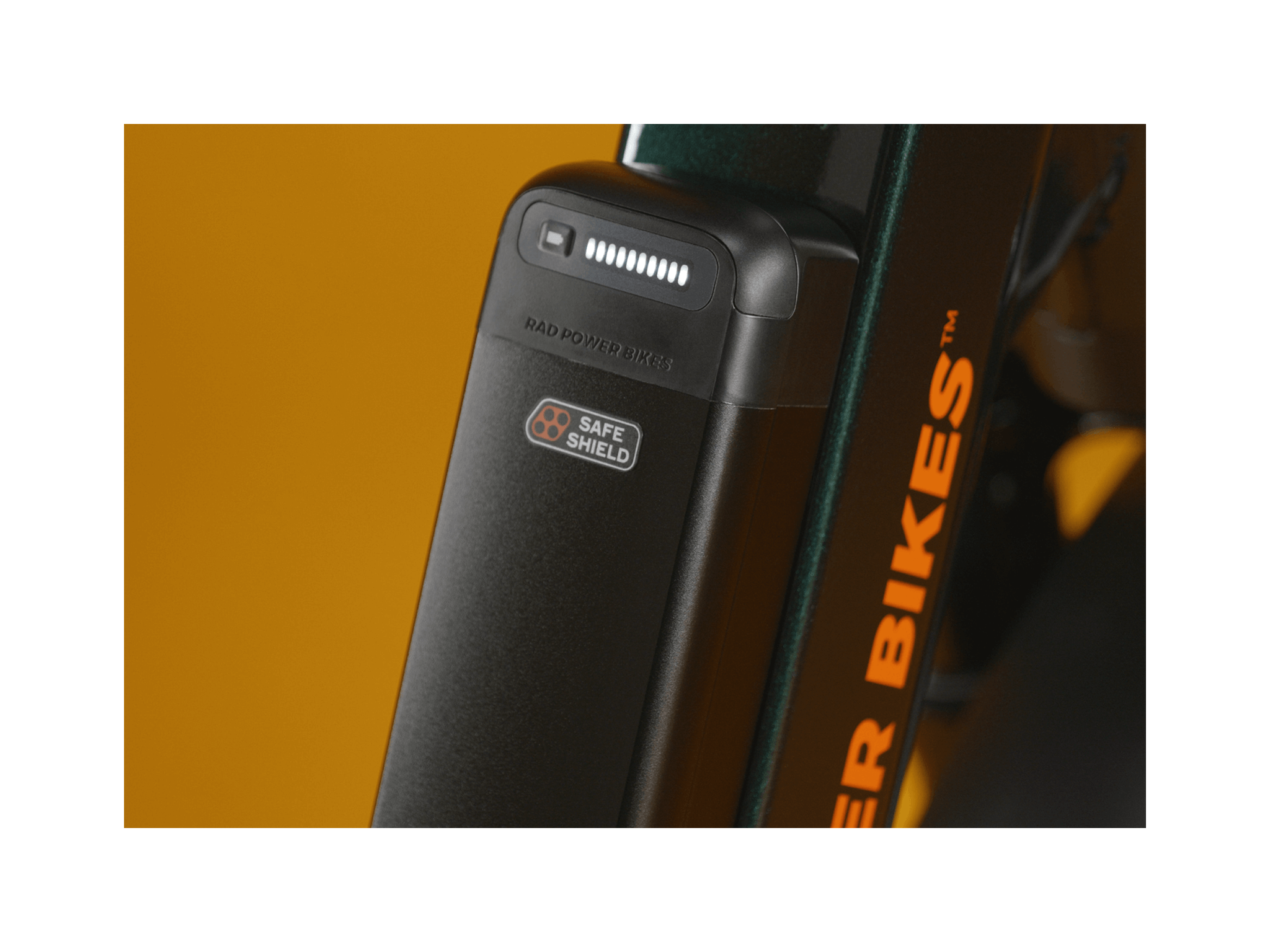 Zoomed in image of a black semi integrated Safe Shield battery on a green bike. 
