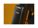 Zoomed in image of a black semi integrated Safe Shield battery on a green bike. 
