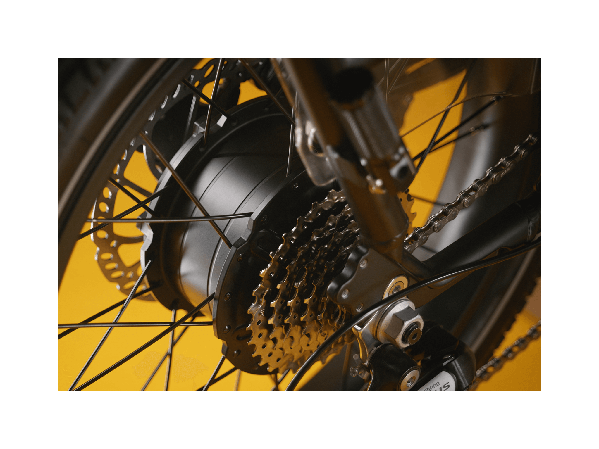 Black ebike motor and chains on a black wheel. 