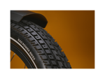 Close up of an ebike tire tread pattern against a gold background.