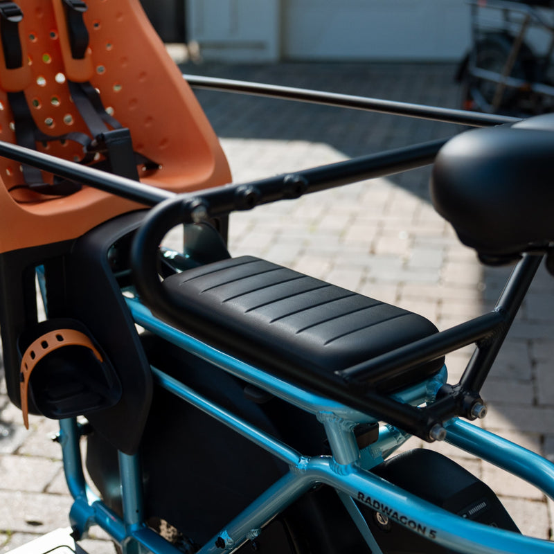 RadWagon 5 Deckpad installed on a blue RadWagon 5 electric cargo bike, with an orange thule yepp chilld seat and a caboose installed. 