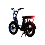 Photo of a Rad Power Bikes RadRunner electric cargo bike with passenger package and Rad logo taillight turned on and mounted below rear seat on the rack.
