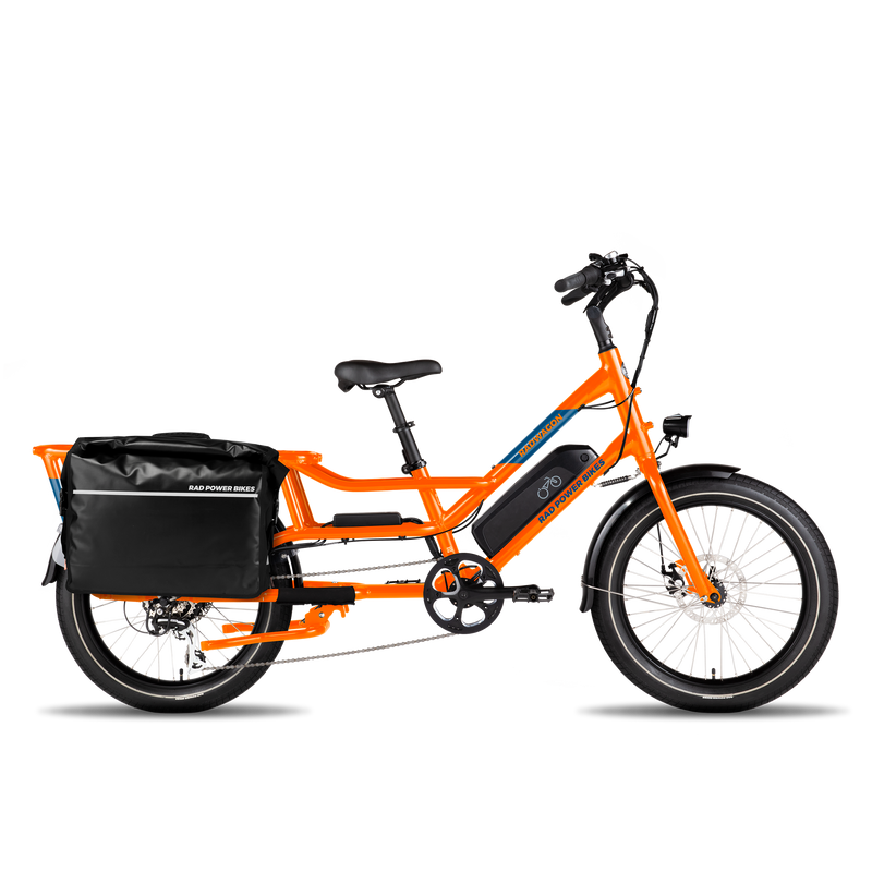 Full side view of an orange RadWagon with a fully-loaded black Ballard Cargo Bag on the rear rack.