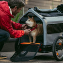 Rad Trailer Pet Insert on the grass in a park with a dog inside, with the back panel unzipped.